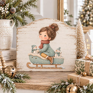 Whimsical Christmas girl on a sled with snowmen transfer on a scalloped wooden sign.