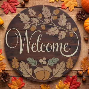 Round wooden 'Welcome' sign with autumn leaf and acorn motifs, styled on burlap with fall leaves, acorns, pinecones, and pumpkins around it.