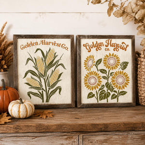 Two framed rustic autumn wall signs on a wooden surface. The left sign reads 'Golden Harvest Co.